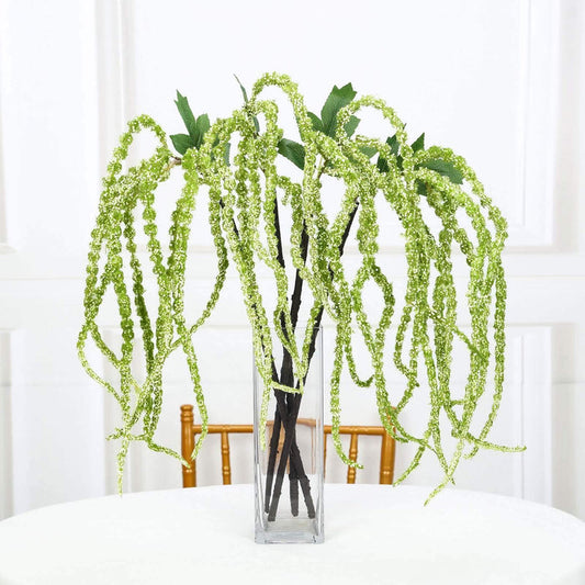 Artificial green hanging plant in a clear vase.
