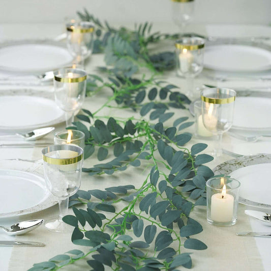 Elegant table setting with greenery, candles, and dinnerware for a stylish dining experience.