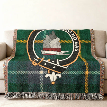 MacNeil clan crest tartan woven throw blanket draped over sofa — full pattern in clan colours