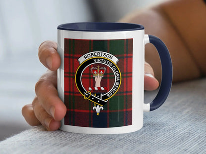 Navy-accent Robertson mug held in a hand, showing the crowned-hand crest and Virtutis Gloria Merces motto.