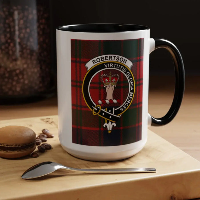Black-accent Robertson crest mug on a tabletop beside a macaron, coffee beans and spoon.