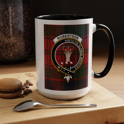 Black-accent Robertson crest mug on a tabletop beside a macaron, coffee beans and spoon.