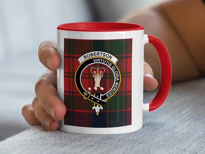 Red-accent Robertson crest mug held in a hand, with a tartan background.