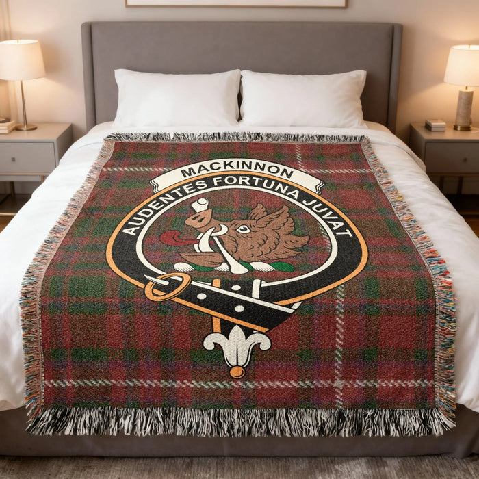 MacKinnon Family Crest woven blanket with fringed edges on a bed