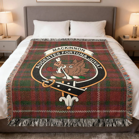 MacKinnon Family Crest woven blanket with fringed edges on a bed