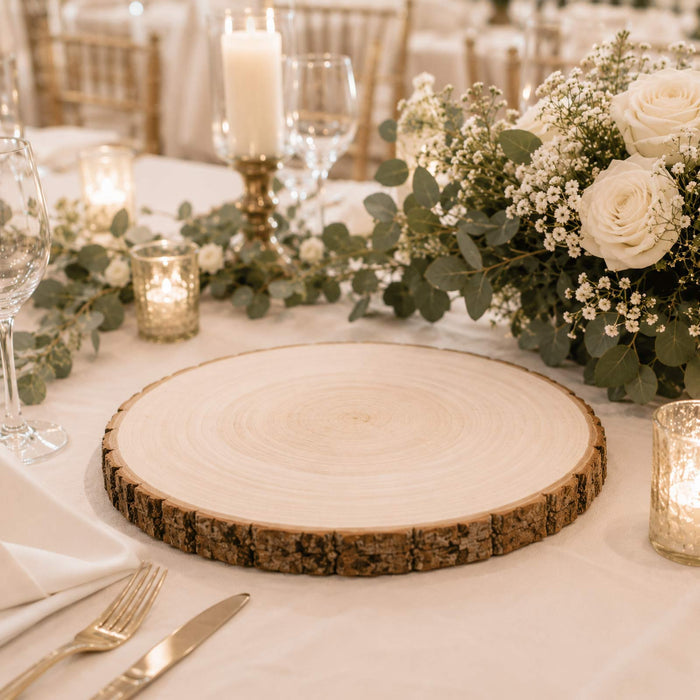 Elegant wedding table setting with rustic wood slice charger and white floral centerpiece