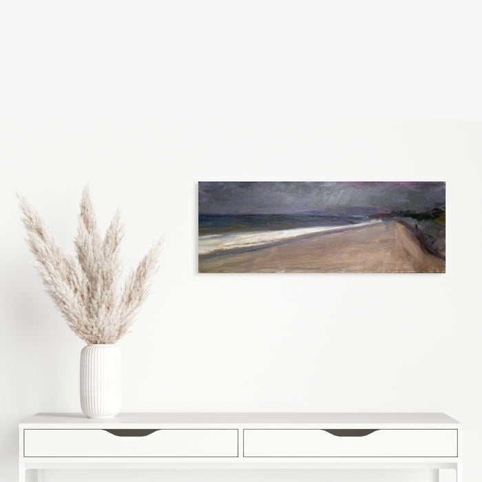 The artwork 'Sandy Hook' by Peter Colquhoun depicts a moody coastal landscape with a sweeping sandy beach curving along dark waters. Stormy grey clouds hover above, creating dramatic contrast with the beige shoreline. Oil on linen technique brings rich texture and depth to the seascape, capturing the raw beauty of the coastline.