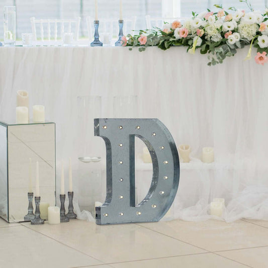 Decorative marquee letter 'D' with lights at an elegant event setting.