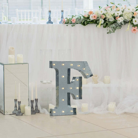 Decorative illuminated letter "F" at a wedding reception.