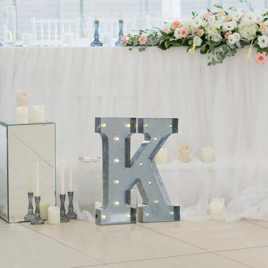 Decorative marquee letter "K" with lights at a wedding reception.